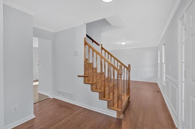 stairs with hardwood / wood-style floors and crown molding