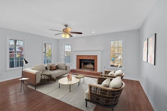 living room with hardwood / wood-style floors, a brick fireplace, plenty of natural light, and ceiling fan