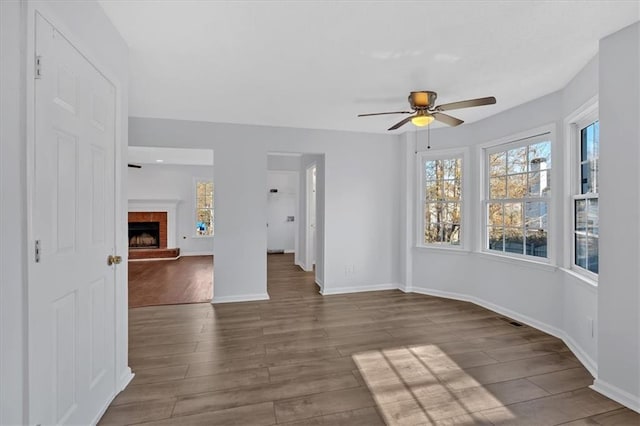 spare room featuring hardwood / wood-style flooring, ceiling fan, and a fireplace