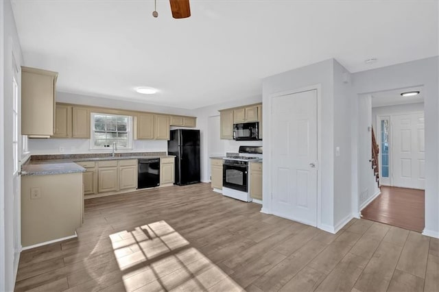 kitchen featuring ceiling fan, sink, cream cabinets, light hardwood / wood-style floors, and black appliances