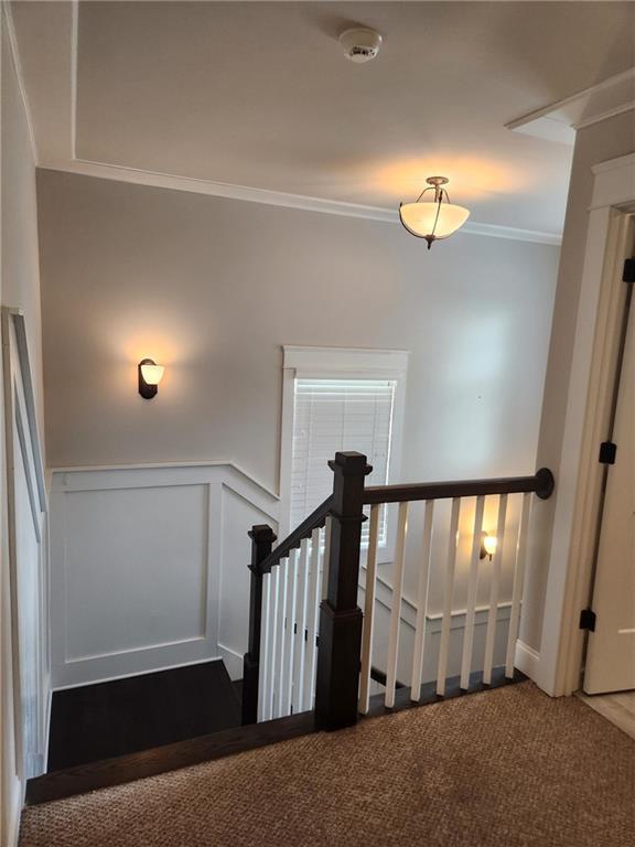 2439 Muirfield Pl, Atlanta, GA 30337 - staircase featuring ornamental molding, wainscoting, carpet flooring, and a decorative wall