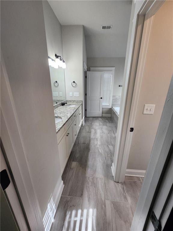 2439 Muirfield Pl, Atlanta, GA 30337 - full bath with double vanity, a bath, and baseboards