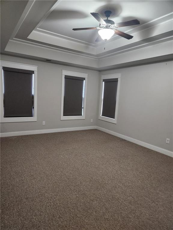 2439 Muirfield Pl, Atlanta, GA 30337 - carpeted empty room with a tray ceiling, baseboards, and a ceiling fan