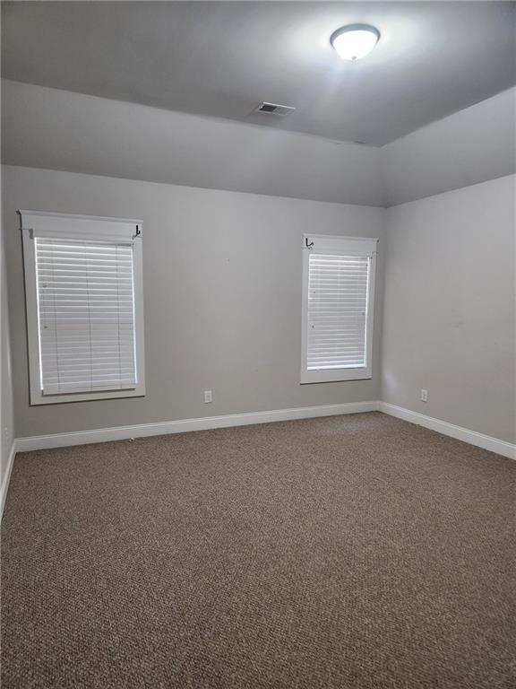 2439 Muirfield Pl, Atlanta, GA 30337 - carpeted spare room with baseboards and vaulted ceiling