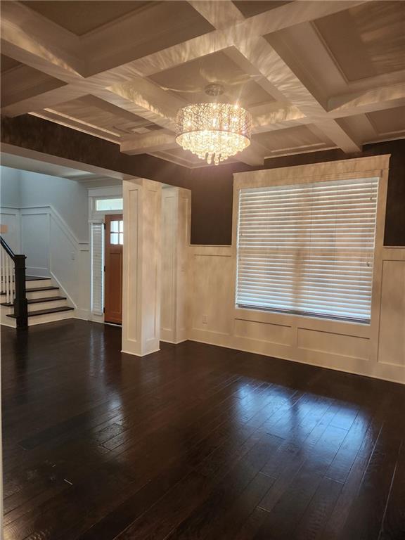 2439 Muirfield Pl, Atlanta, GA 30337 - unfurnished room featuring coffered ceiling, stairway, dark wood-style floors, a chandelier, and a decorative wall