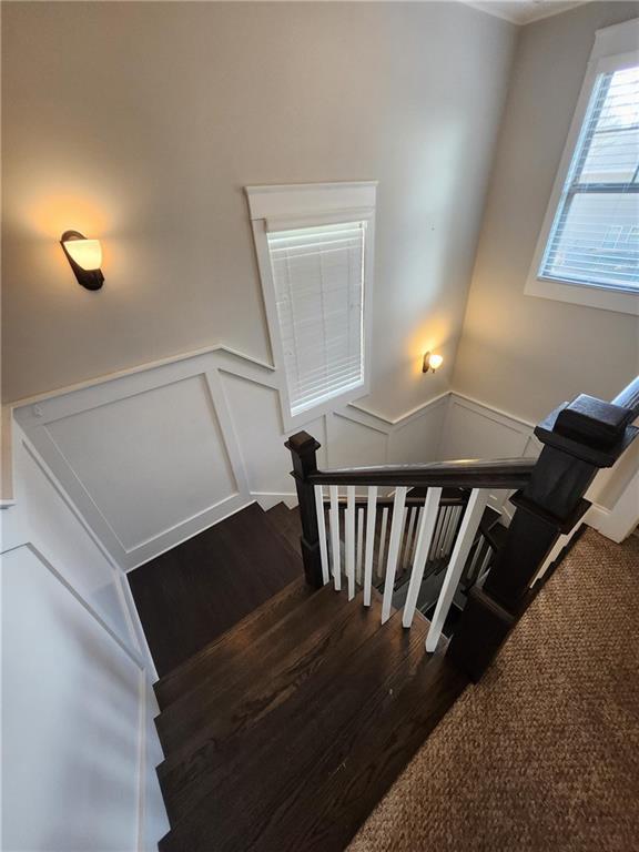 2439 Muirfield Pl, Atlanta, GA 30337 - stairs with a decorative wall, wood finished floors, and a wainscoted wall