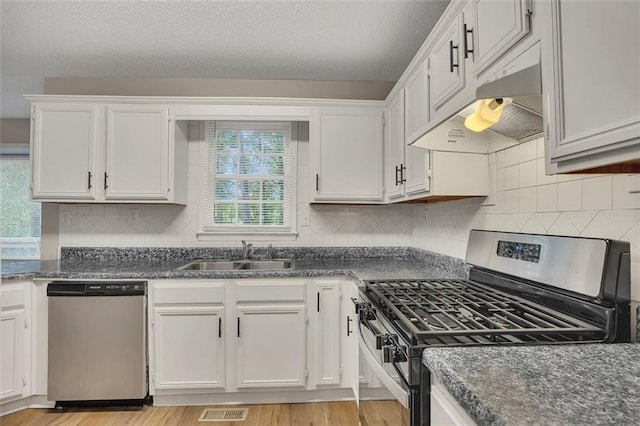 kitchen with a sink, stainless steel appliances, visible vents, under cabinet range hood, and white cabinets