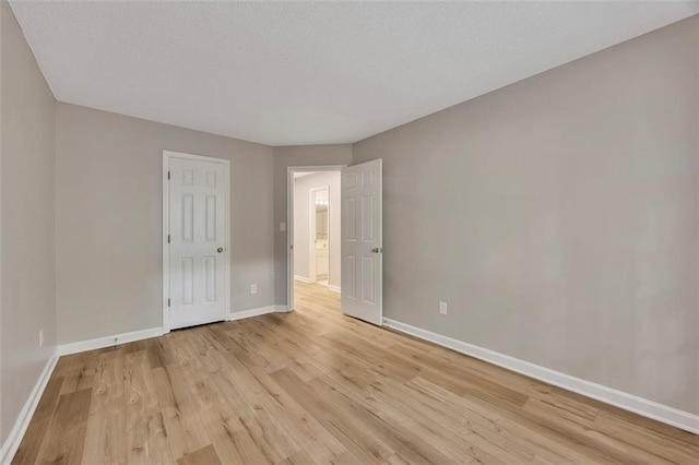 unfurnished bedroom featuring light wood-style floors and baseboards
