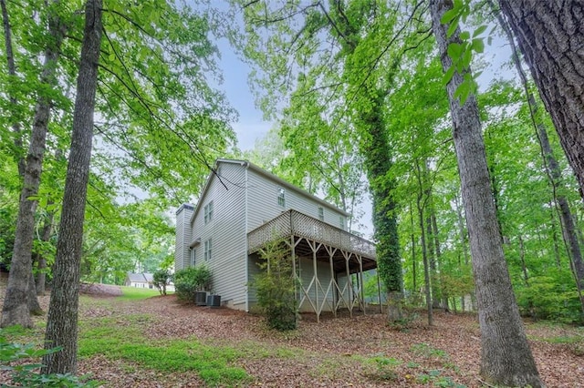 exterior space featuring central air condition unit and a wooden deck