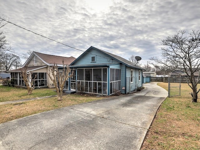 view of front of home featuring a front yard and a sunroom