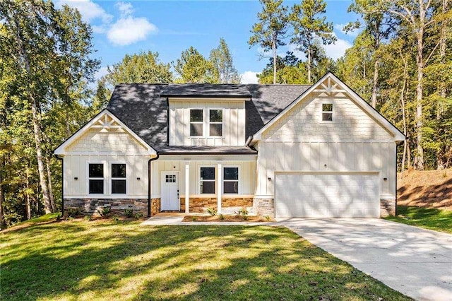 view of front of house featuring a garage, concrete driveway, a front lawn, and board and batten siding