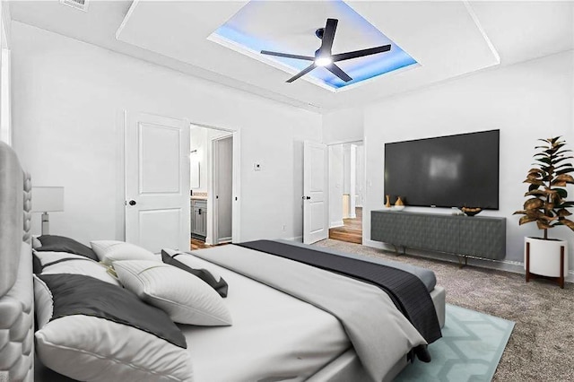 bedroom featuring carpet floors, baseboards, ceiling fan, and ensuite bath