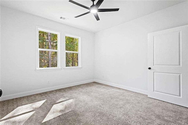 spare room featuring a ceiling fan, carpet, visible vents, and baseboards