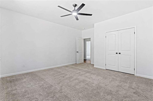 unfurnished bedroom with carpet, baseboards, ceiling fan, and a closet