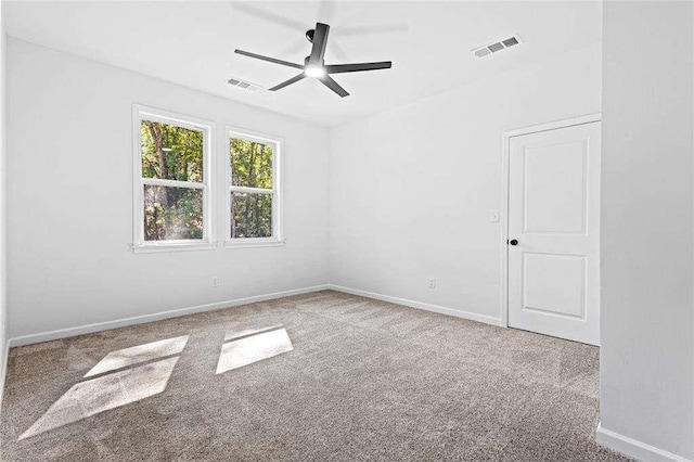 carpeted empty room featuring visible vents, ceiling fan, and baseboards