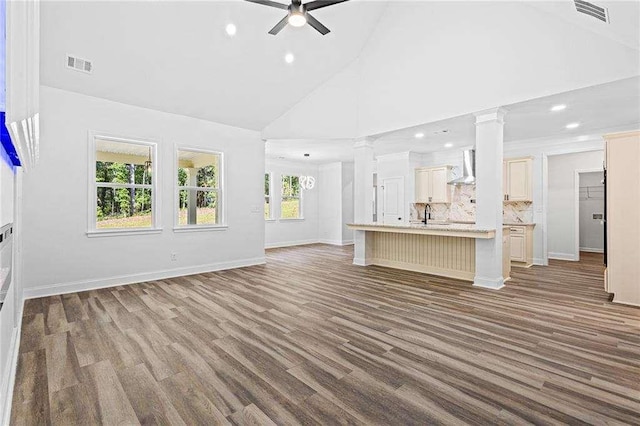 unfurnished living room featuring ceiling fan, high vaulted ceiling, visible vents, and ornate columns