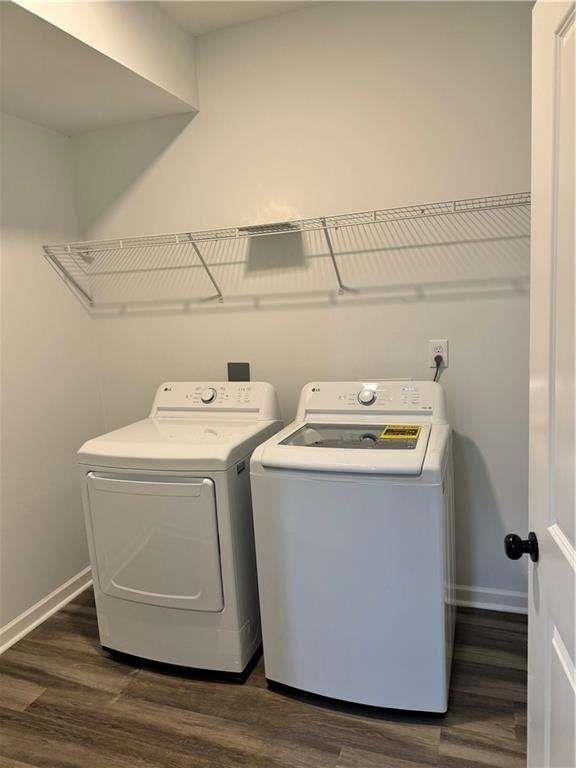 washroom featuring laundry area, dark wood-type flooring, independent washer and dryer, and baseboards