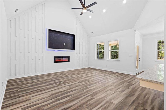 unfurnished living room featuring wood finished floors, visible vents, a ceiling fan, baseboards, and a glass covered fireplace