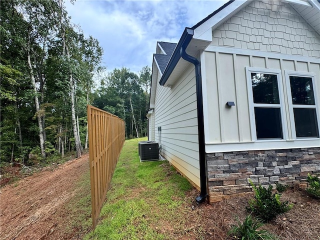 view of home's exterior featuring a lawn, central AC unit, and board and batten siding