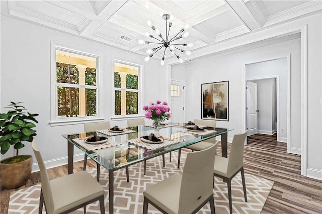 dining area with a chandelier, ornamental molding, wood finished floors, and baseboards