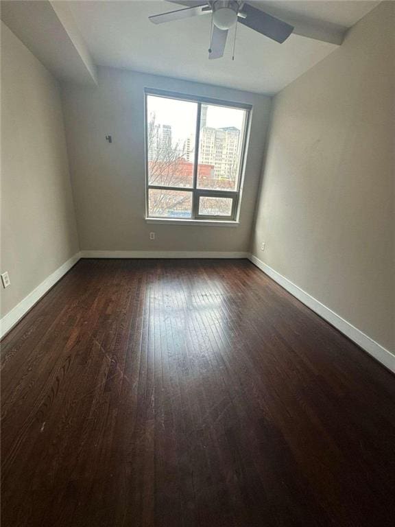 unfurnished room with dark hardwood / wood-style floors and ceiling fan