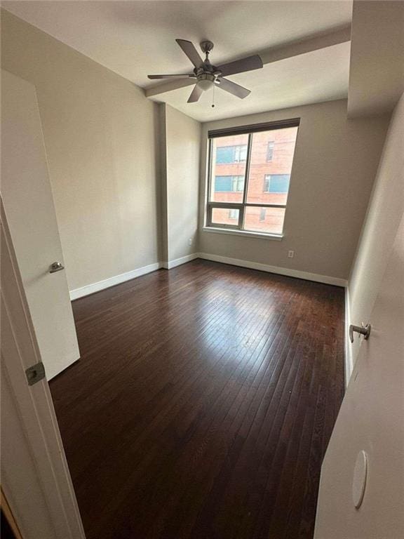 empty room featuring ceiling fan and dark wood-type flooring