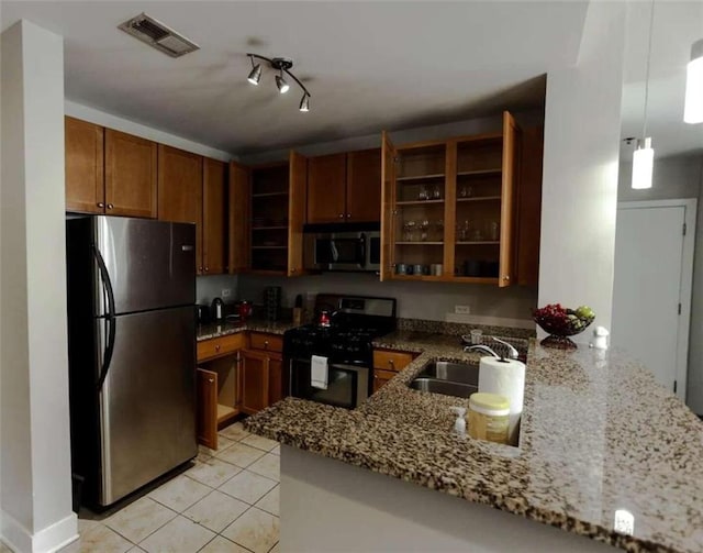 kitchen featuring appliances with stainless steel finishes, kitchen peninsula, sink, and light stone counters