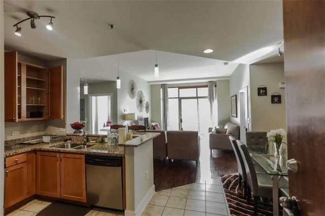 kitchen featuring light hardwood / wood-style floors, dishwasher, stone counters, decorative light fixtures, and sink