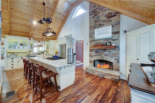 kitchen featuring wood ceiling, visible vents, stainless steel appliances, and wood finished floors