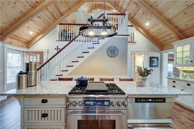 kitchen featuring wood ceiling, wood finished floors, light stone countertops, stainless steel stove, and beam ceiling