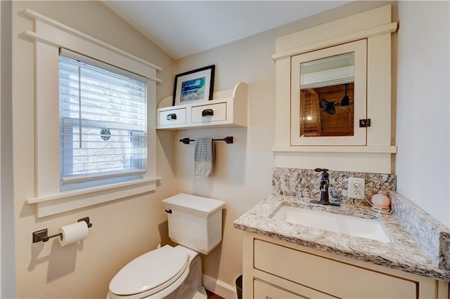 half bath featuring vanity and toilet