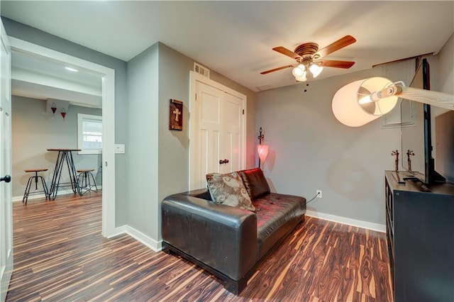 sitting room with a ceiling fan, baseboards, visible vents, and wood finished floors