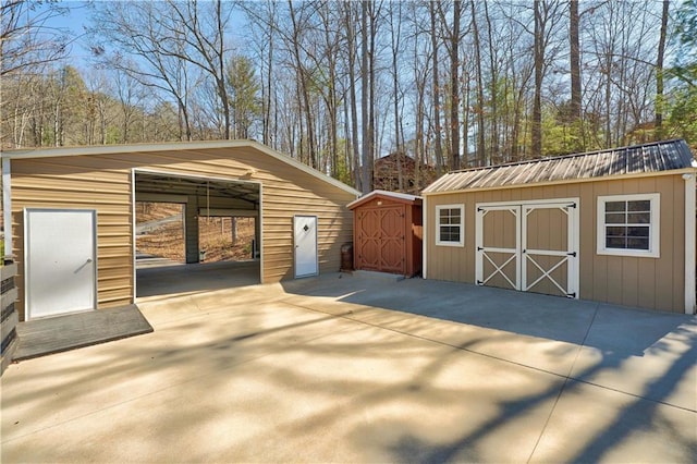 garage featuring a storage shed and concrete driveway