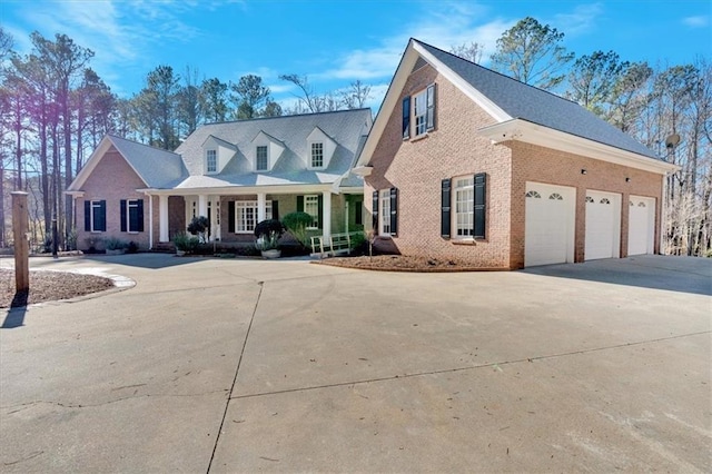 new england style home featuring a garage and a porch