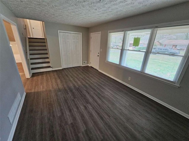unfurnished living room featuring baseboards, stairs, and visible vents