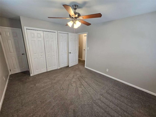 empty room with baseboards, dark carpet, and crown molding