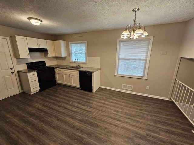 kitchen with dark wood-style flooring, under cabinet range hood, a sink, white cabinets, and black appliances