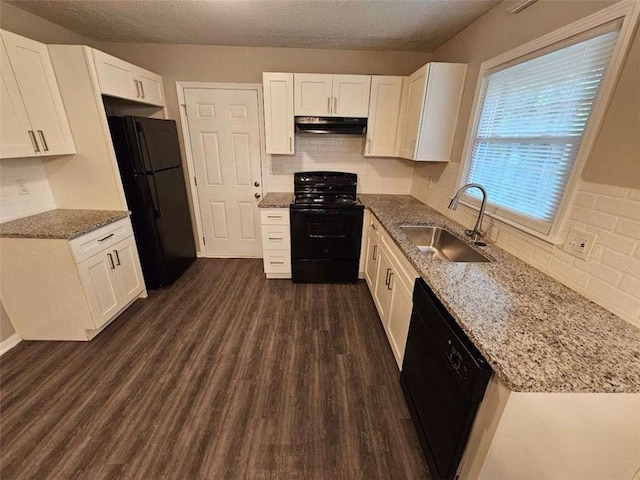 kitchen with dark wood-style flooring, under cabinet range hood, a sink, visible vents, and black appliances