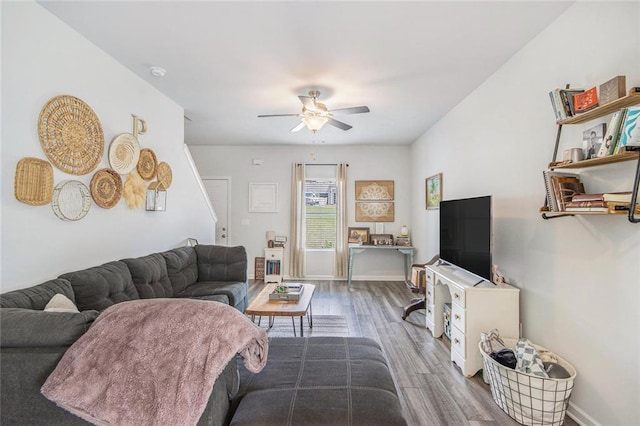 living room with wood finished floors, ceiling fan, and baseboards