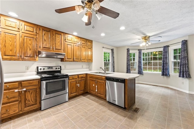 kitchen featuring stainless steel appliances, a ceiling fan, a sink, under cabinet range hood, and recessed lighting