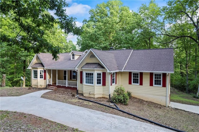 view of front of home with covered porch and a shingled roof
