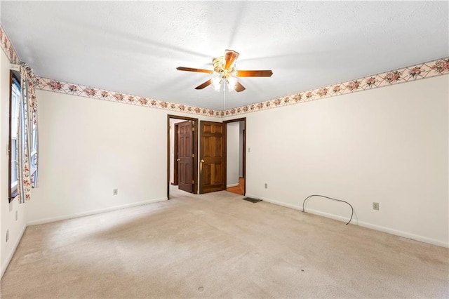 carpeted spare room with ceiling fan and baseboards