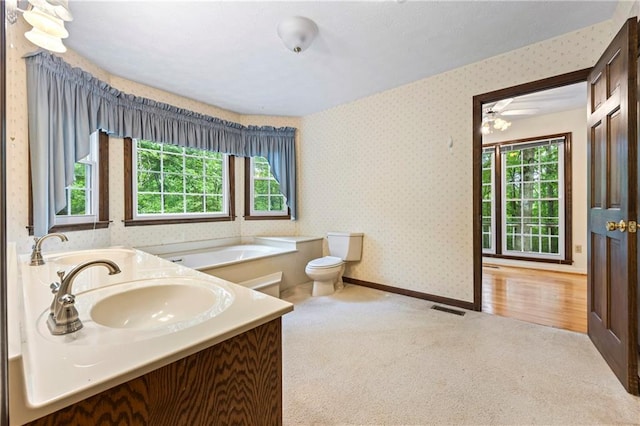 full bathroom with wallpapered walls, a garden tub, baseboards, toilet, and vanity