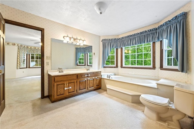 full bath featuring wallpapered walls, toilet, a bath, double vanity, and a textured ceiling