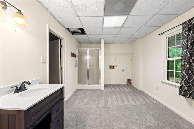 full bathroom featuring a shower stall, vanity, a paneled ceiling, and baseboards