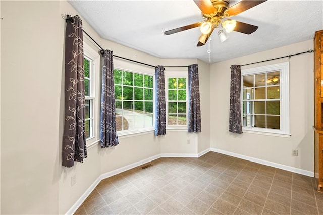 unfurnished room featuring baseboards and a ceiling fan