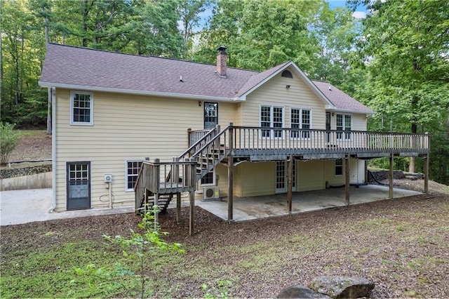rear view of house featuring stairs, a patio, a deck, a chimney, and view of scattered trees