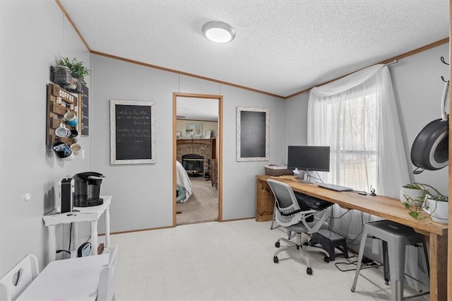 office with ornamental molding, lofted ceiling, a fireplace, and a textured ceiling