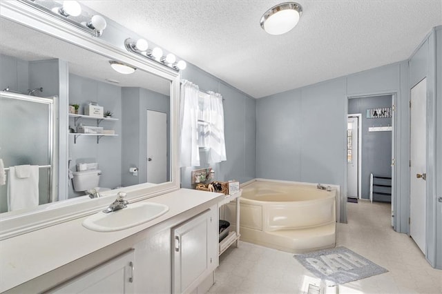 full bathroom featuring tile patterned floors, a garden tub, a textured ceiling, vanity, and a shower stall