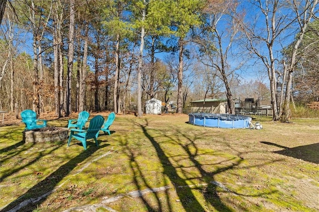 view of yard with an outbuilding, a covered pool, and a shed